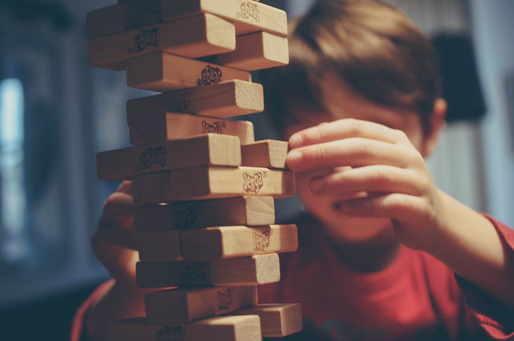 Boy with brown hair nearing the end of a game of Jenga